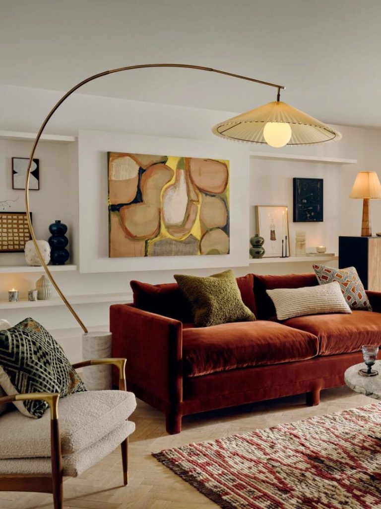 Living room in neutral tones with a dark red sofa and a floor lamp